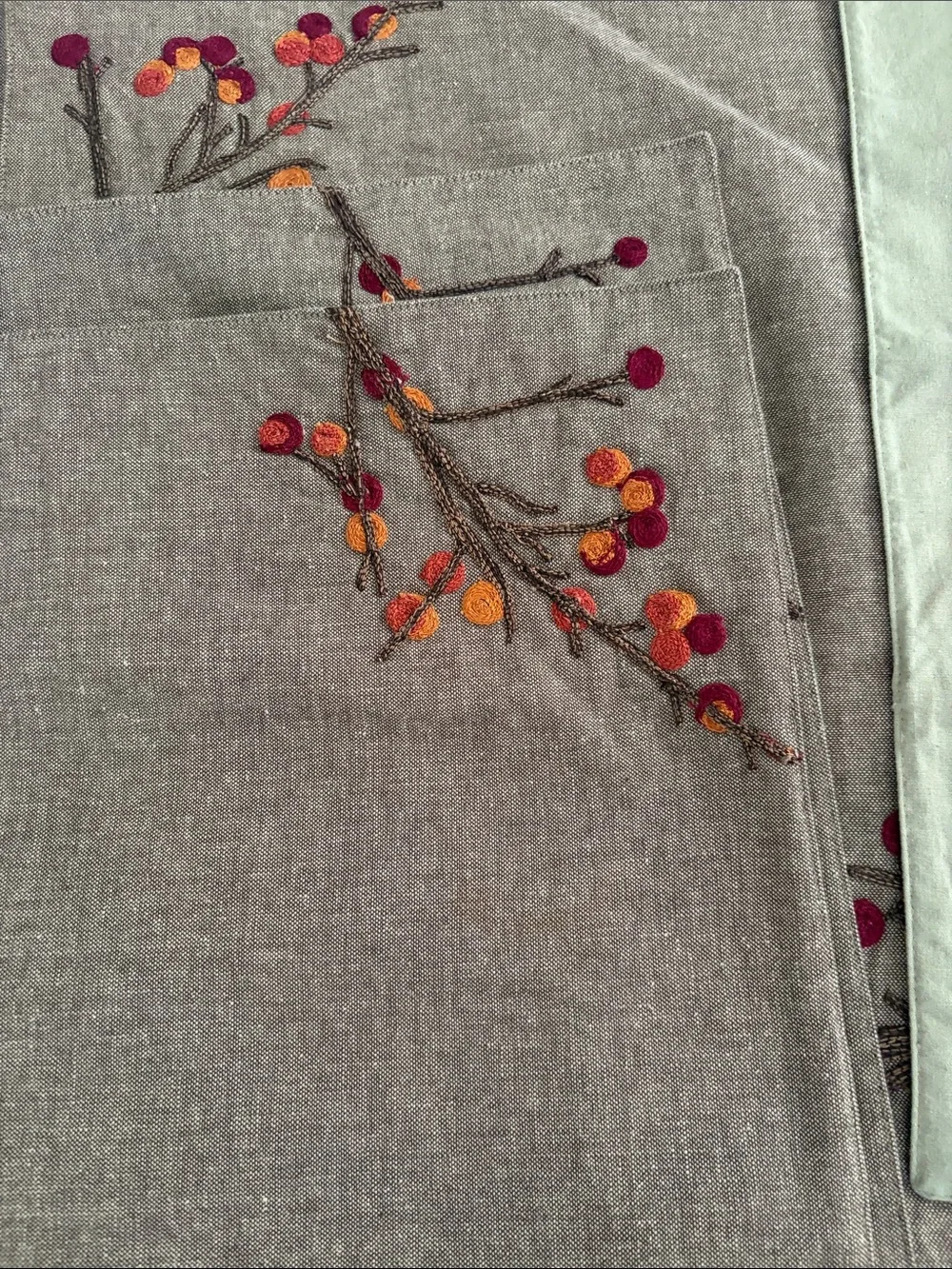 Crate&Barrel Embroidered Placemats with Shades of oranges and reds.